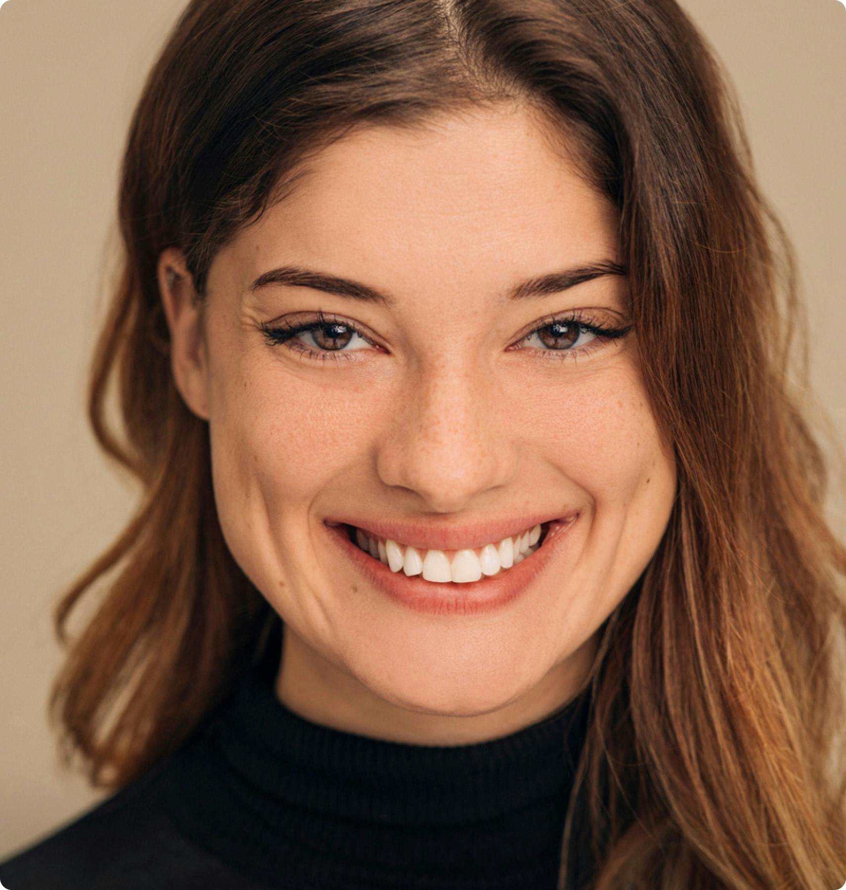 woman with brown hair and freckles smiling