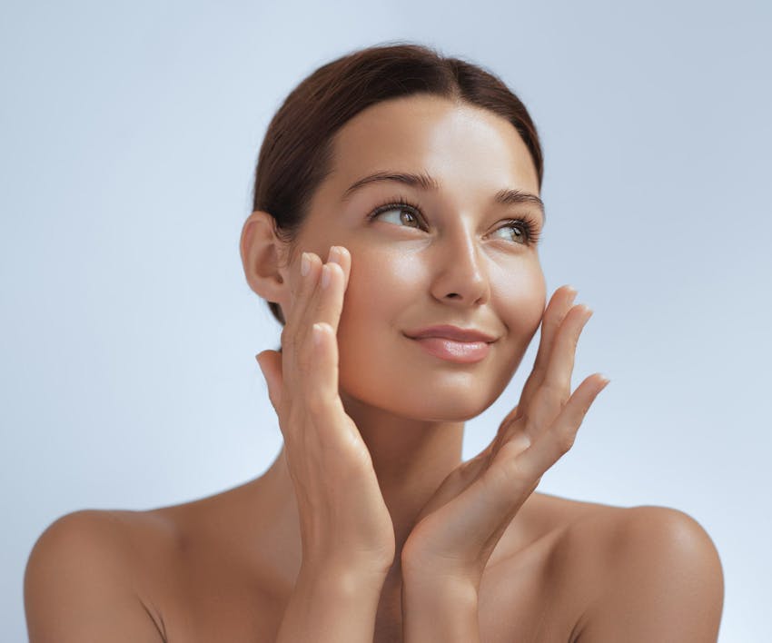 woman touching her cheeks looking away