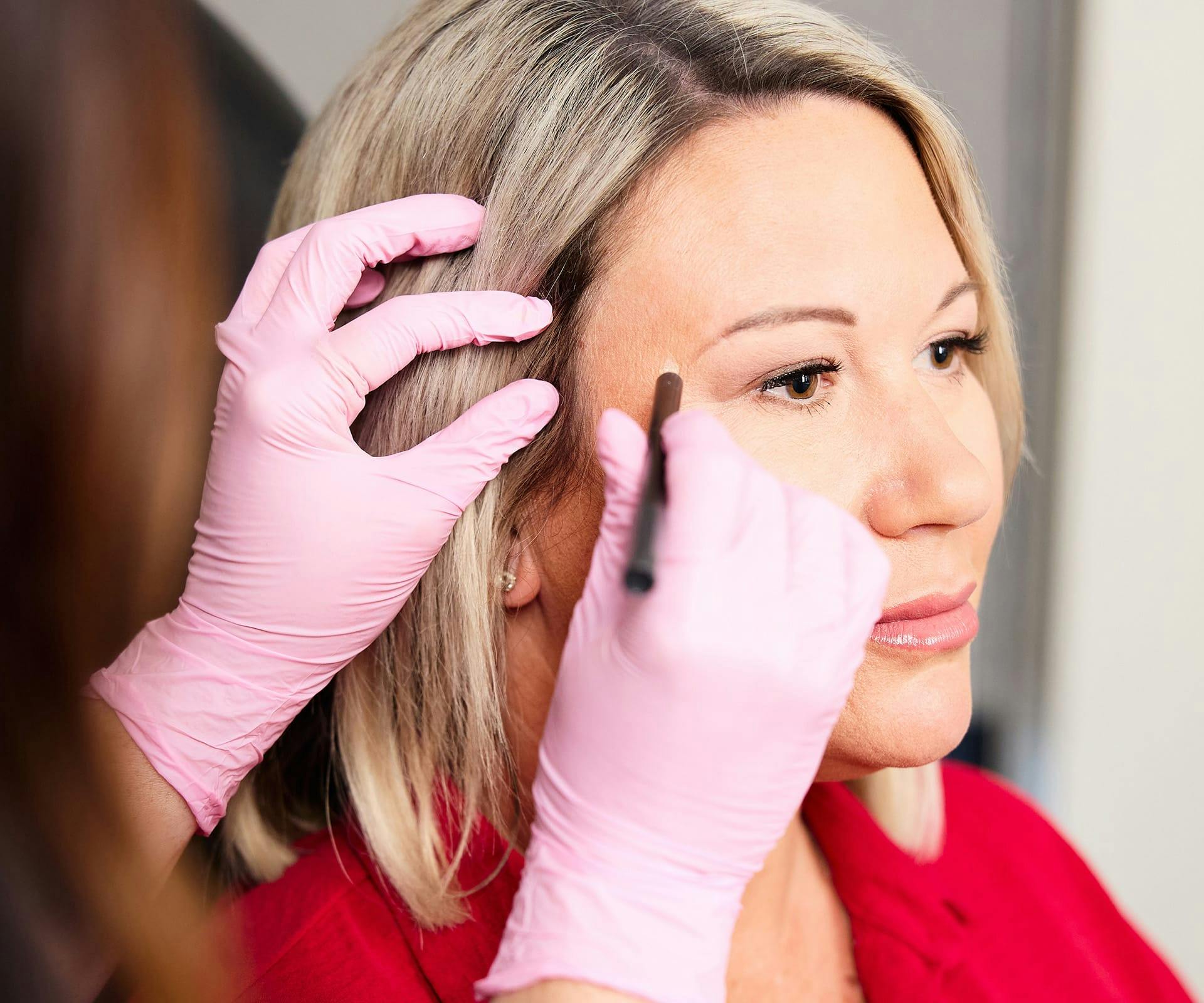 nurse marking on patient's face