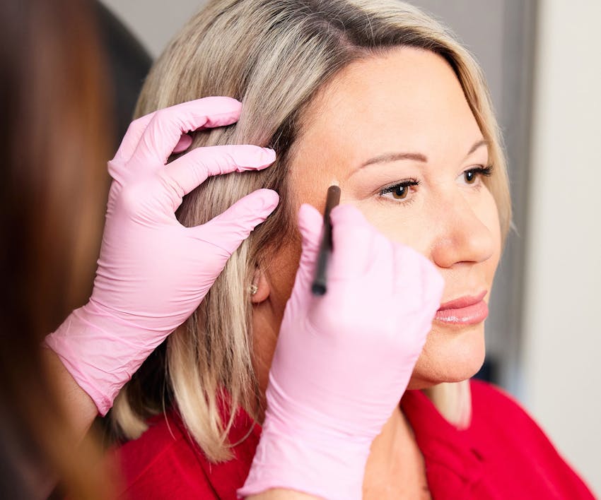 nurse marking on patient's face