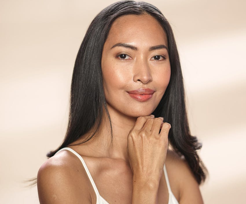 woman smiling with hand under her chin