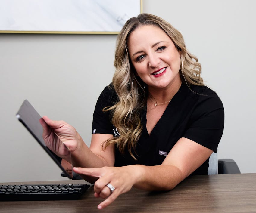nurse holding and pointing to ipad