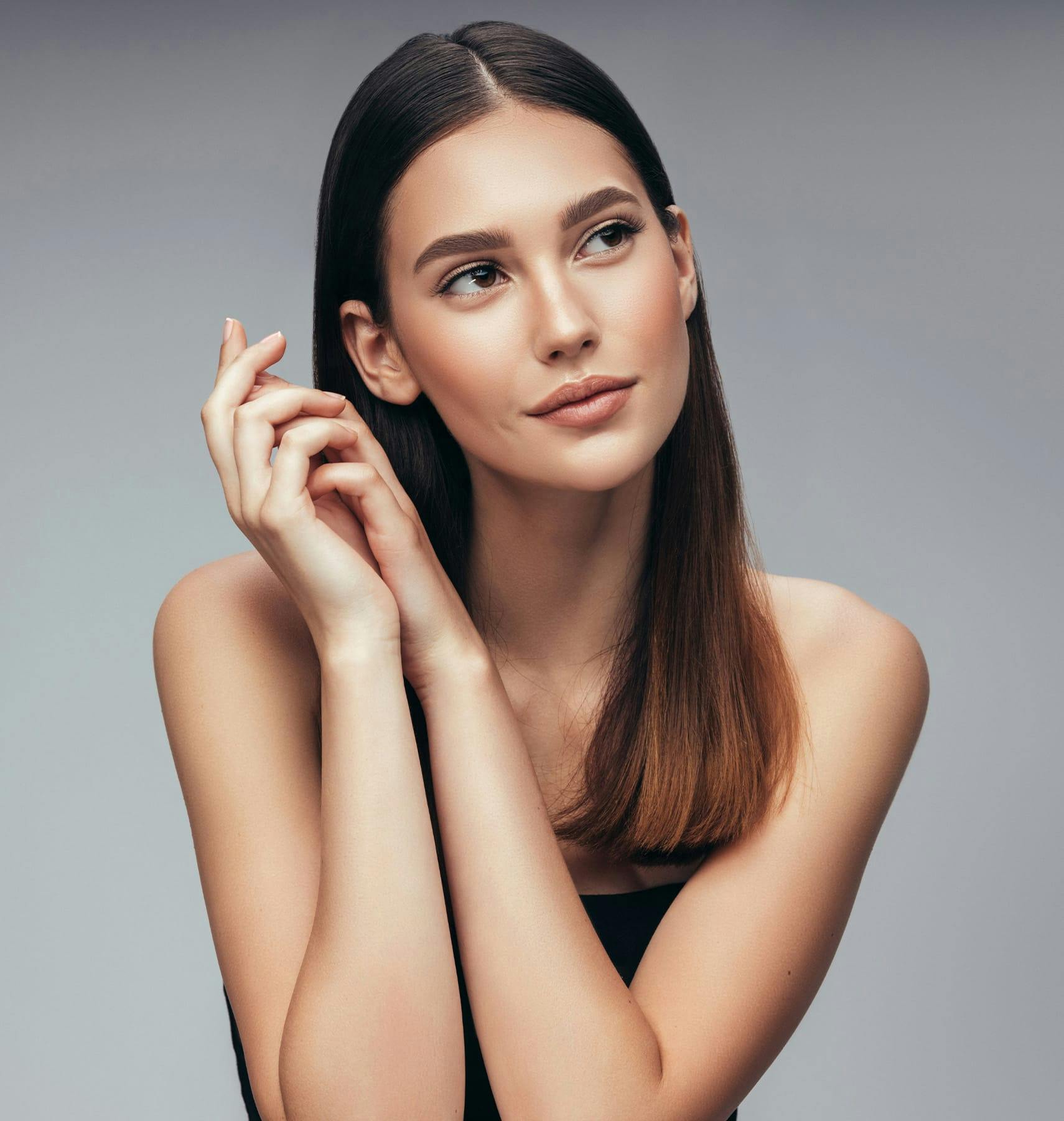 woman looking to the side with her hands holding one another