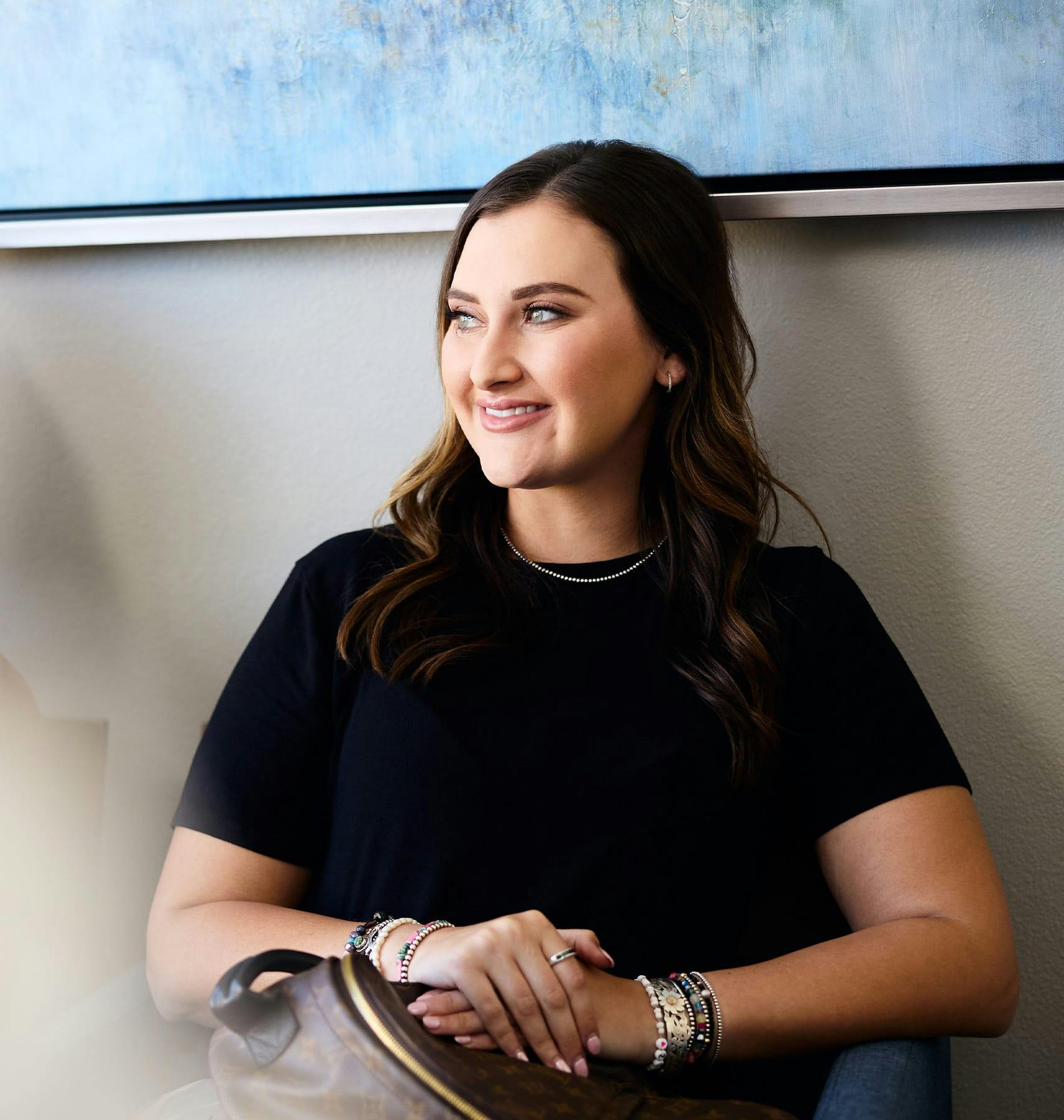 woman sitting in seat with purse in her lap