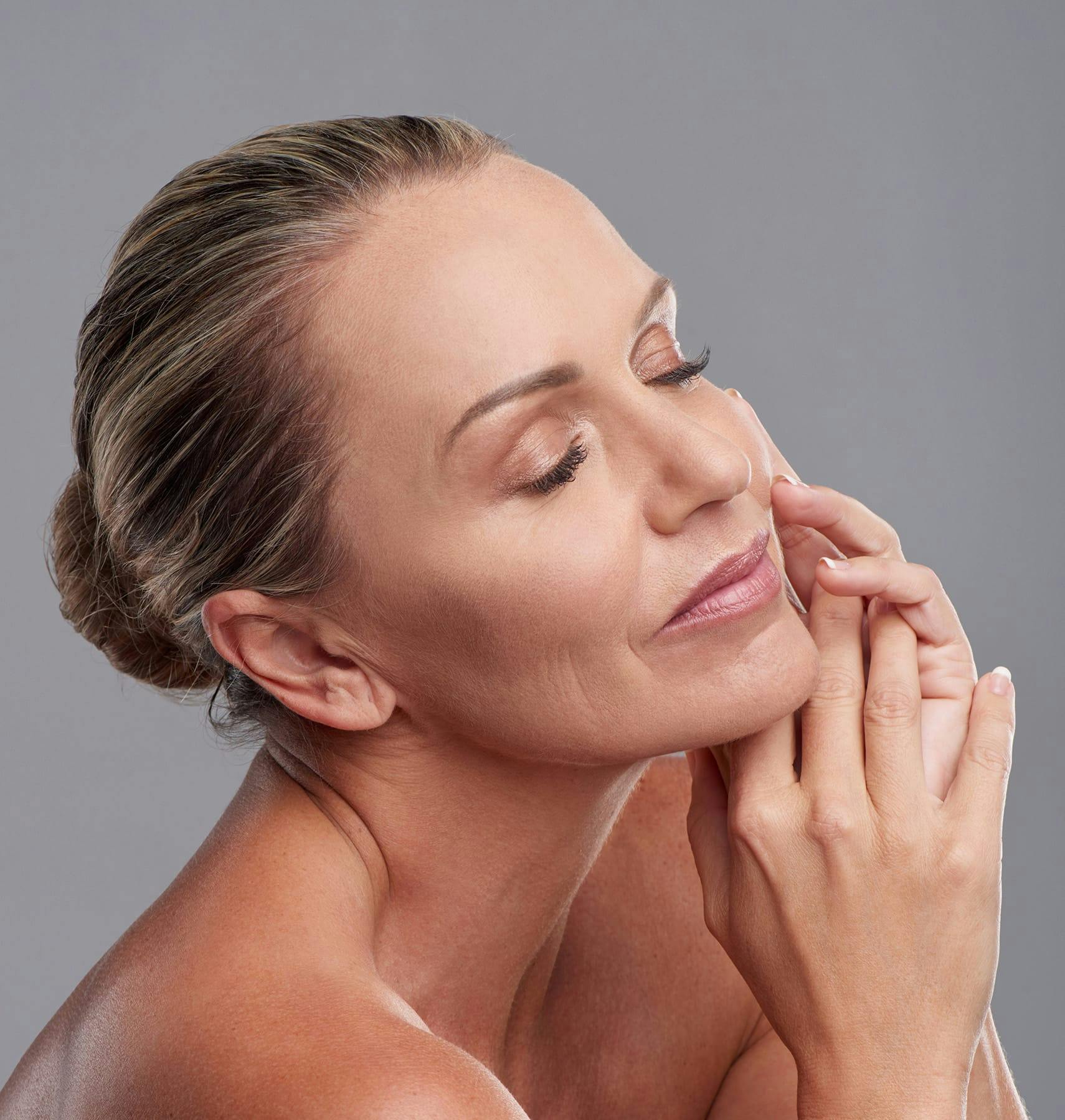 woman closing her eyes and her hands are touching together