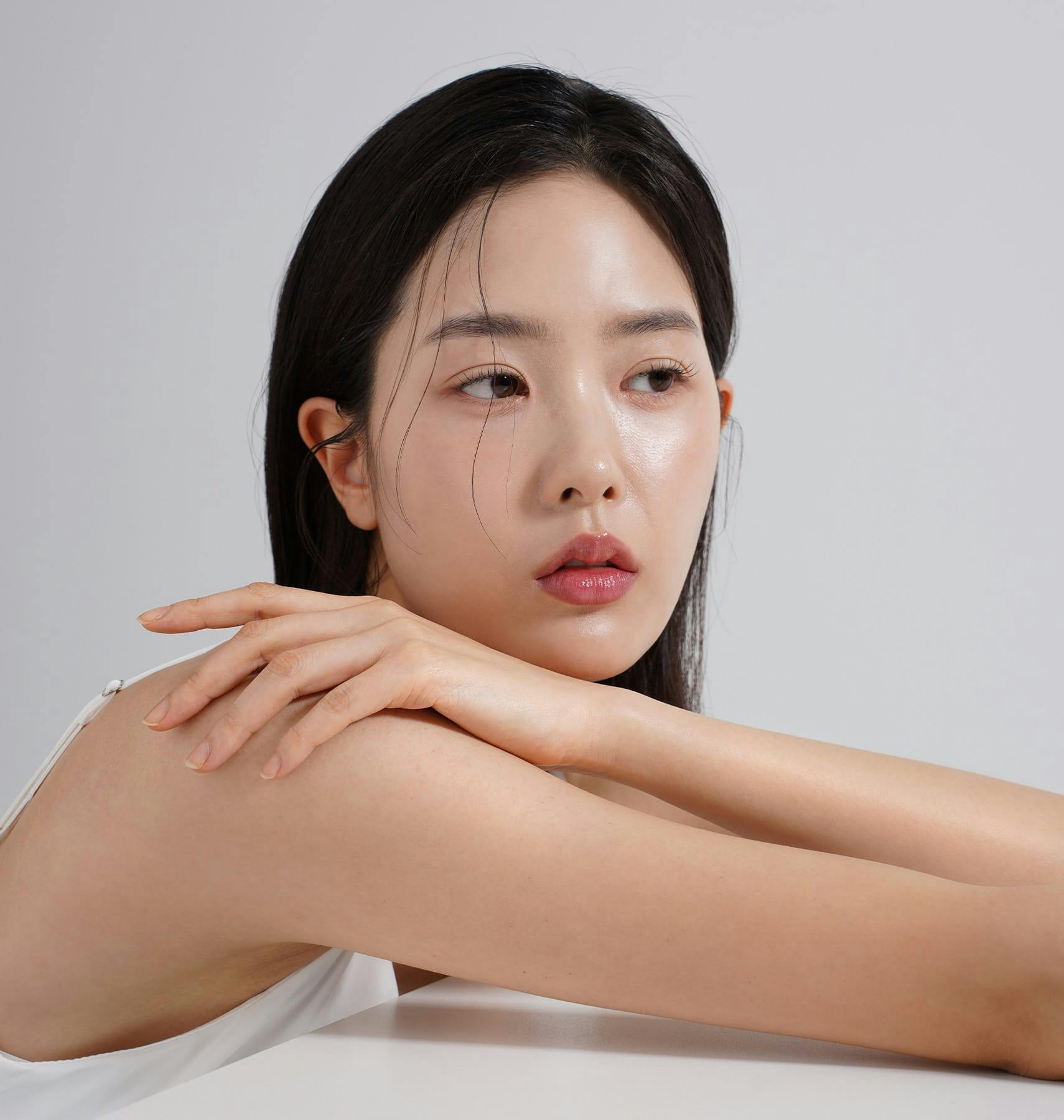 woman leaning on table touching her shoulder