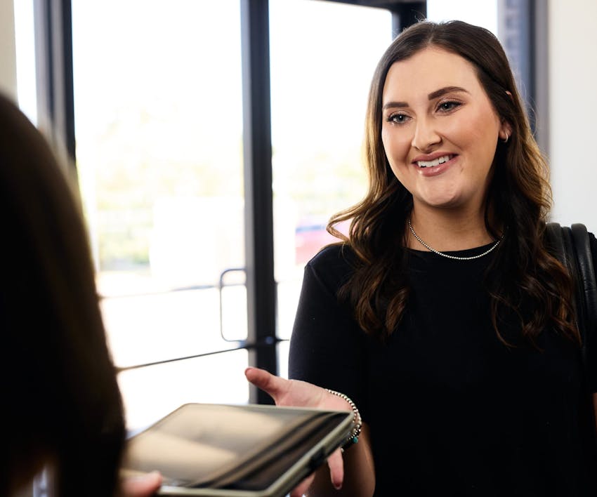 patient handing ipad to receptionist