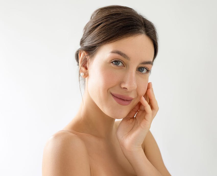 Woman smiling and touching her cheek