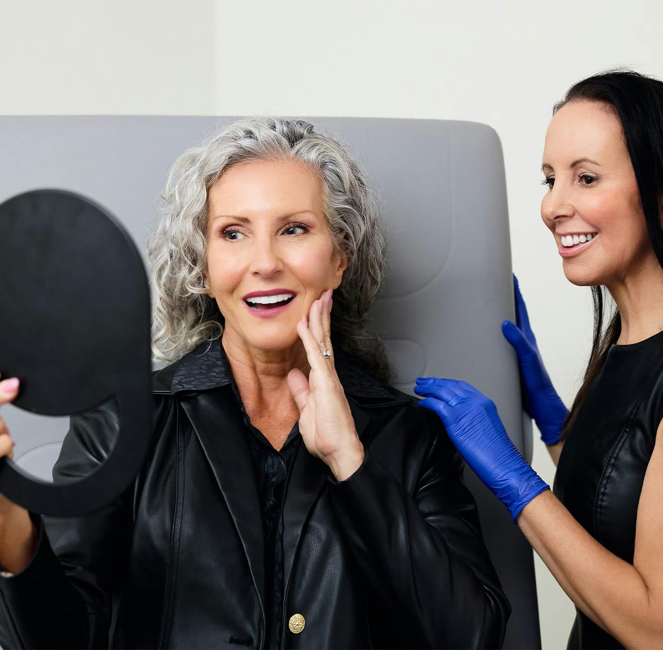 woman looking at herself in a handheld mirror
