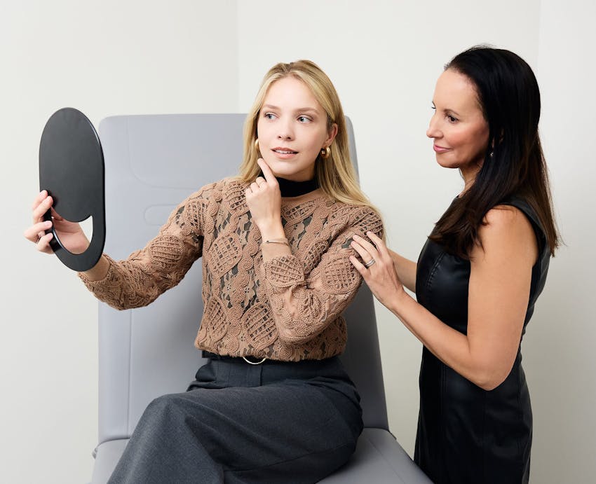 patient looking at her results in a handheld mirror