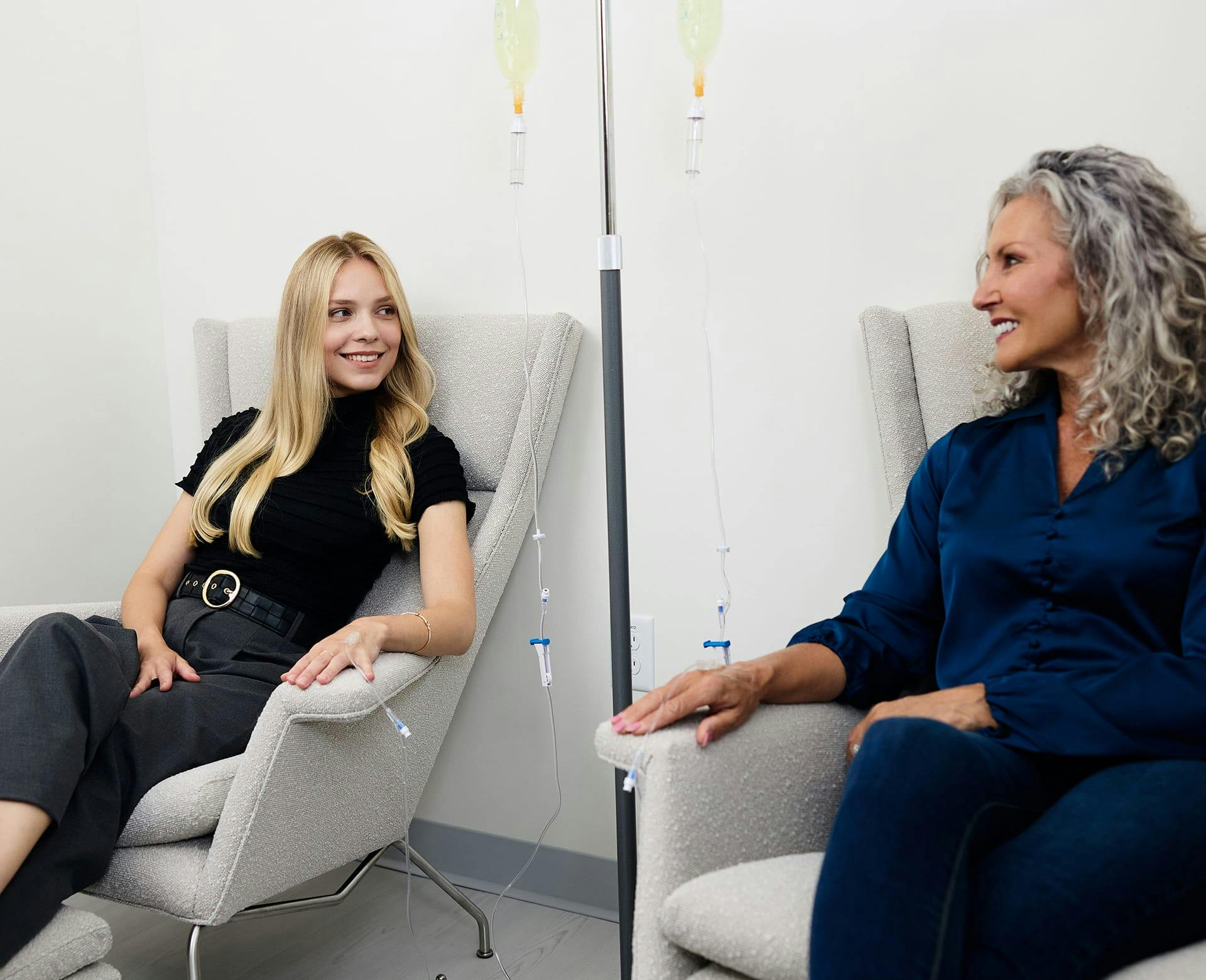 Two women receiving IV treatments