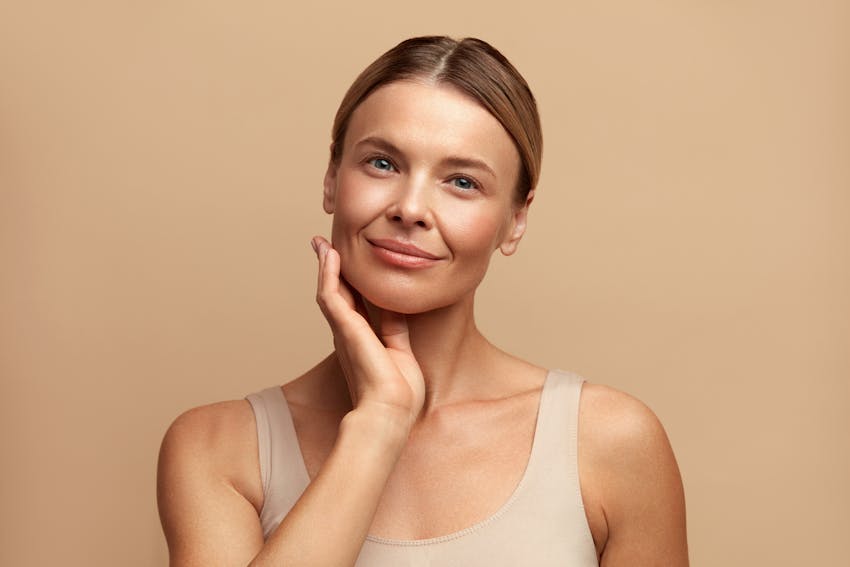 woman with hand on face smiling
