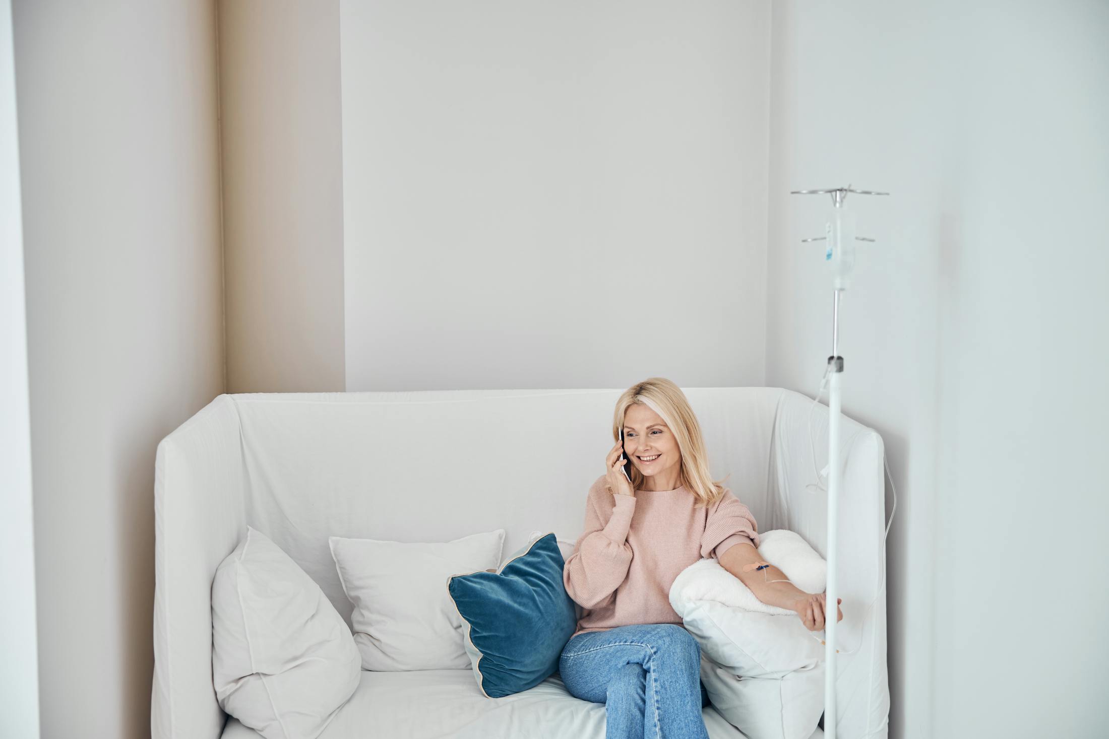Woman sitting on couch getting iv treatment