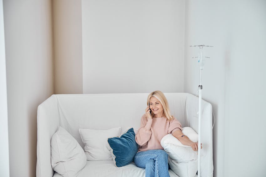 Woman sitting on couch getting iv treatment