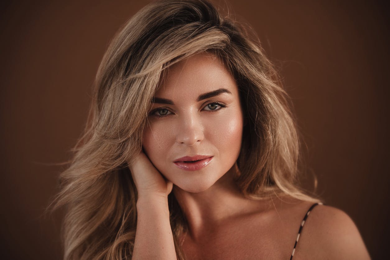 Beauitful woman in late 40s poses in a studio shoot. Her smooth skin emulates the potential results of Botox in Wellesley