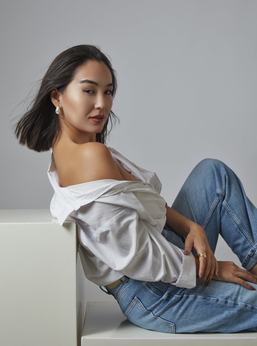Beauitful woman poses in a studio shoot leaning against a block prop. Her smooth skin emulates the potential results of Botox in Wellesley