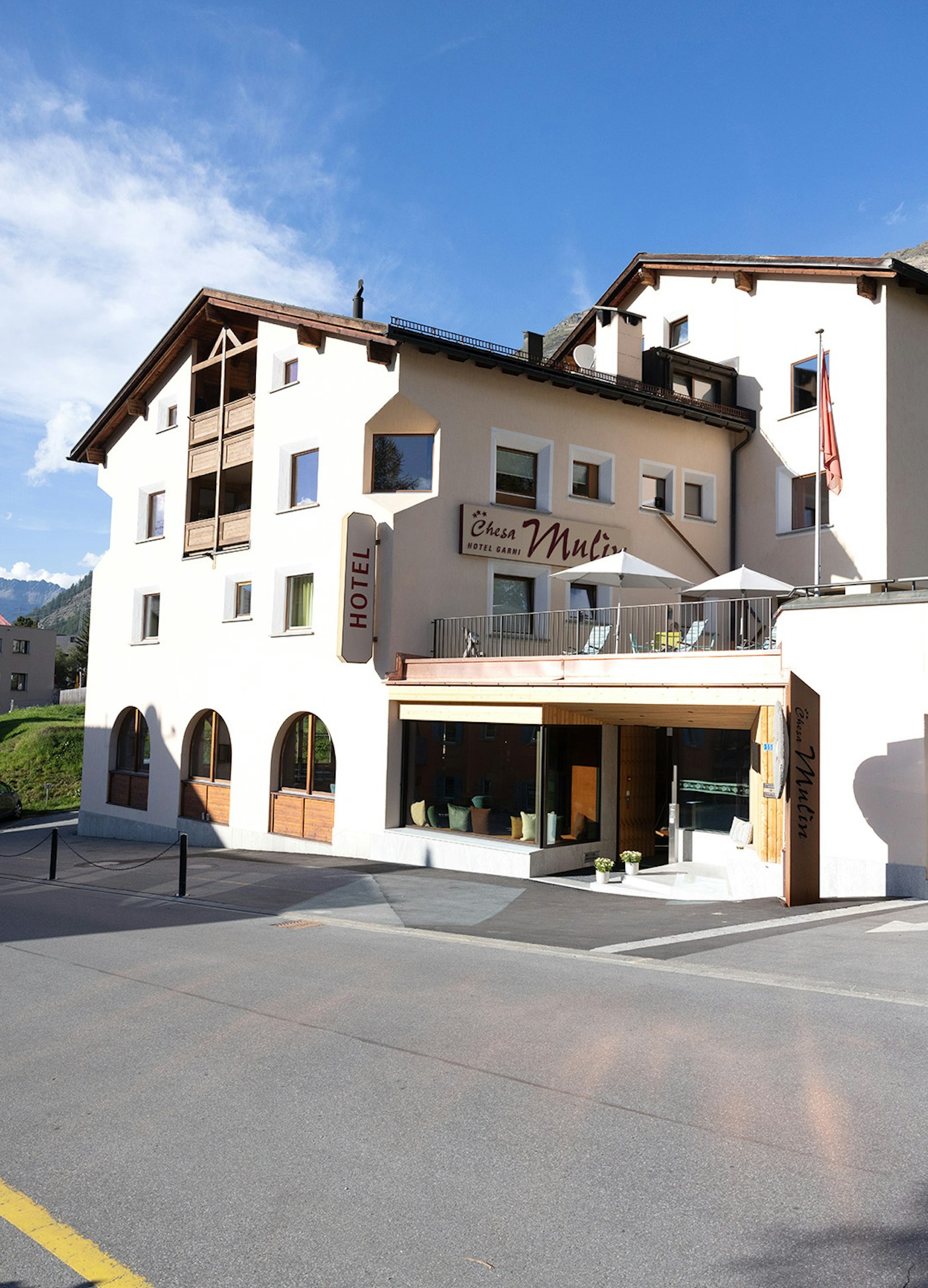 Hotel von aussen im Sommer, ganzes Hotel mit Eingang und Terrasse ersichtlich