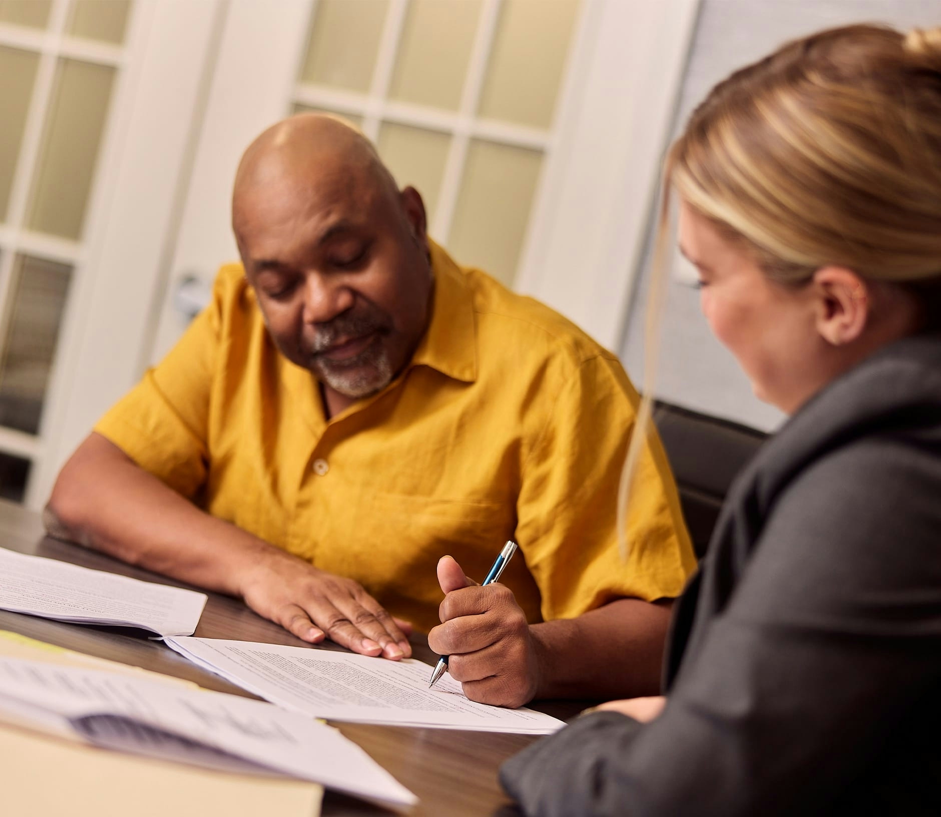 client filling out paper work next to attorney