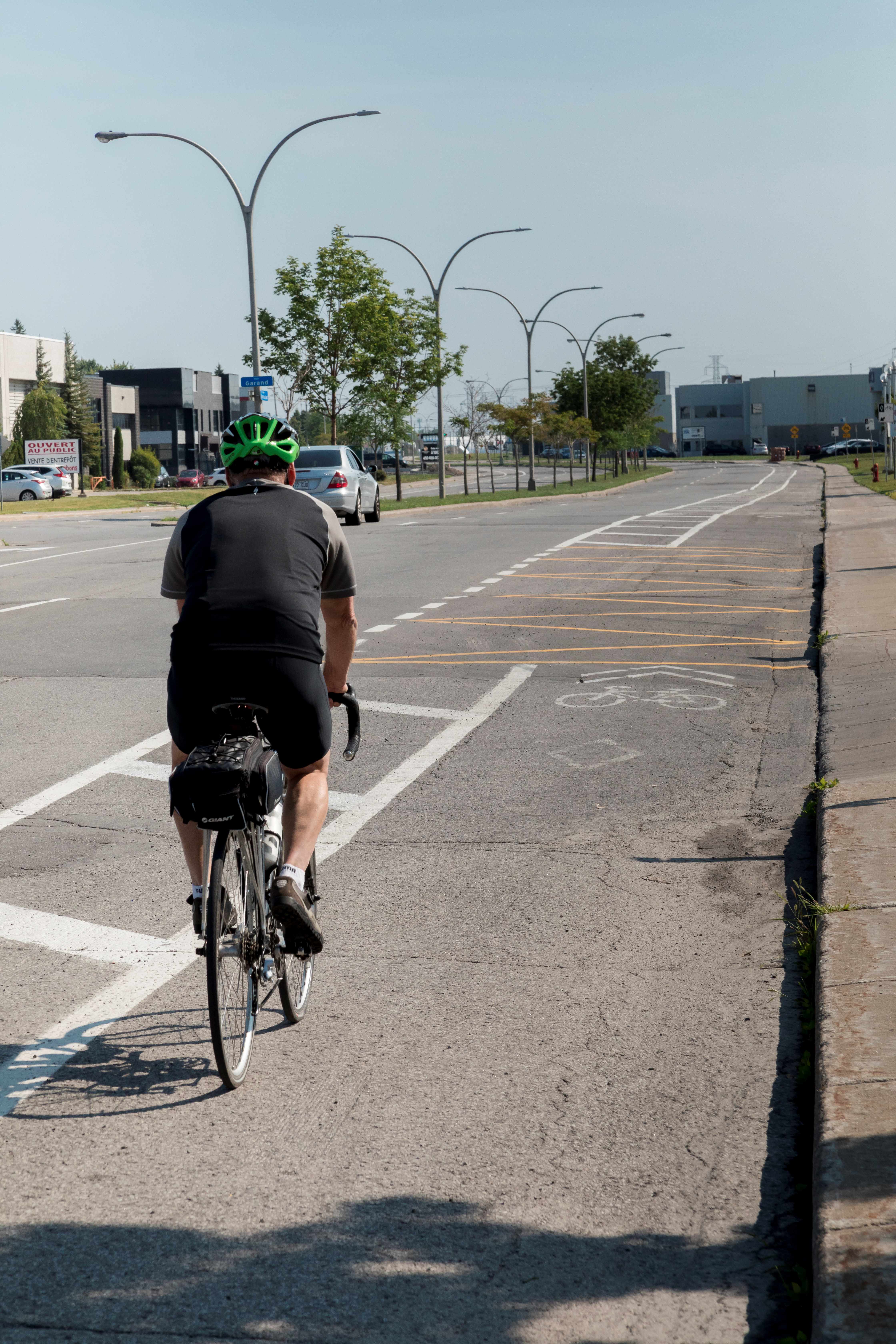 Cyclist riding on a cycle lane with a buffer zone separating them from motor traffic
