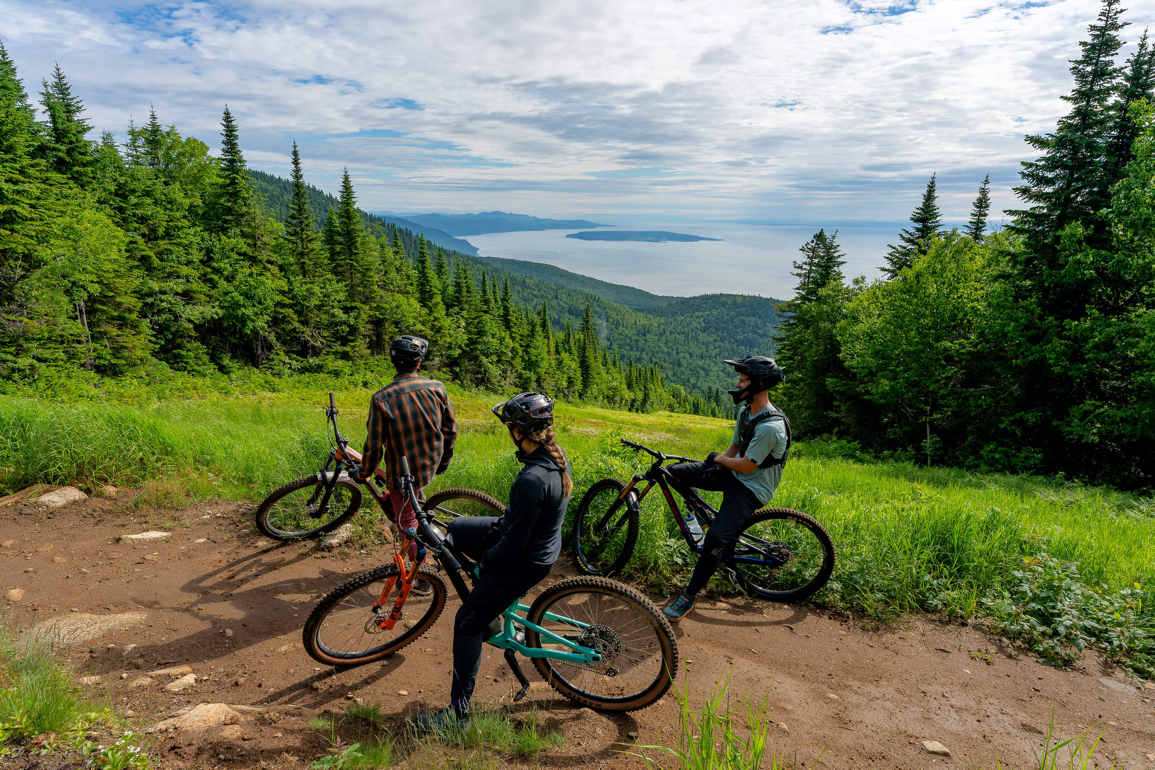 Pratiquants de vélo de montagne avec un panorama sur une étendue d'eau
