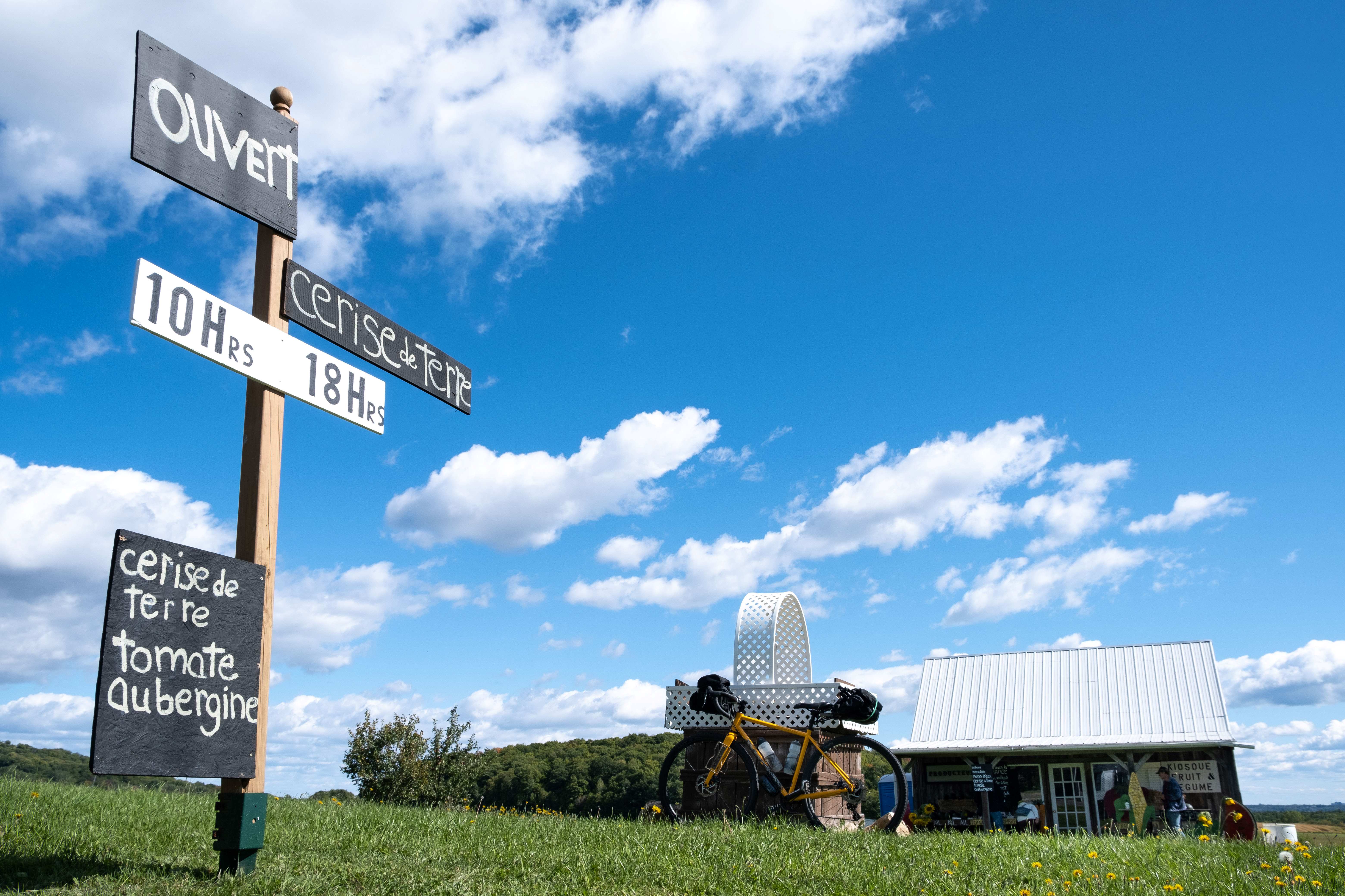Vélo équipé avec des sacoches devant une boutique à la campagne
