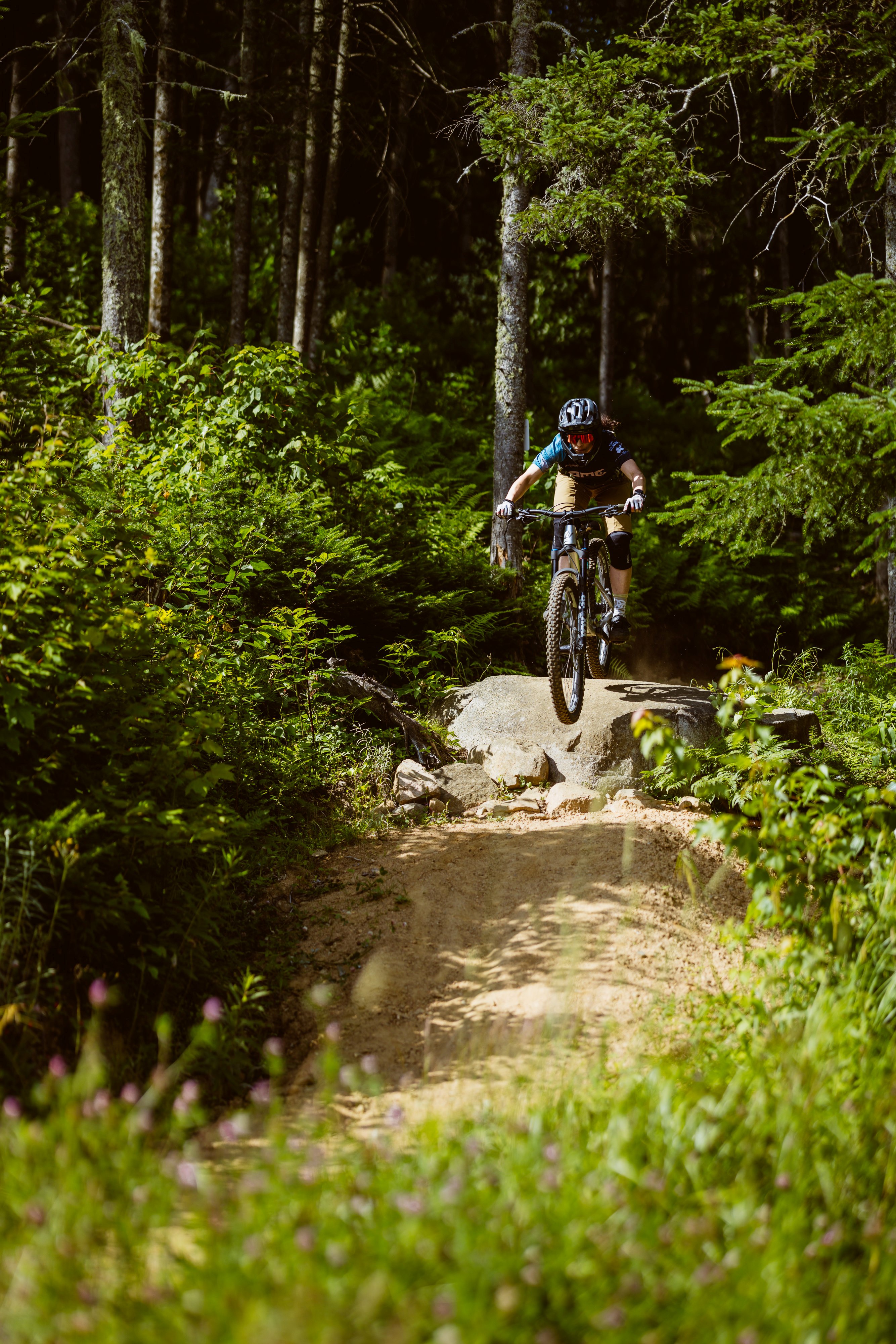 Pratiquante de vélo de montagne (enduro) sur un sentier dans les bois