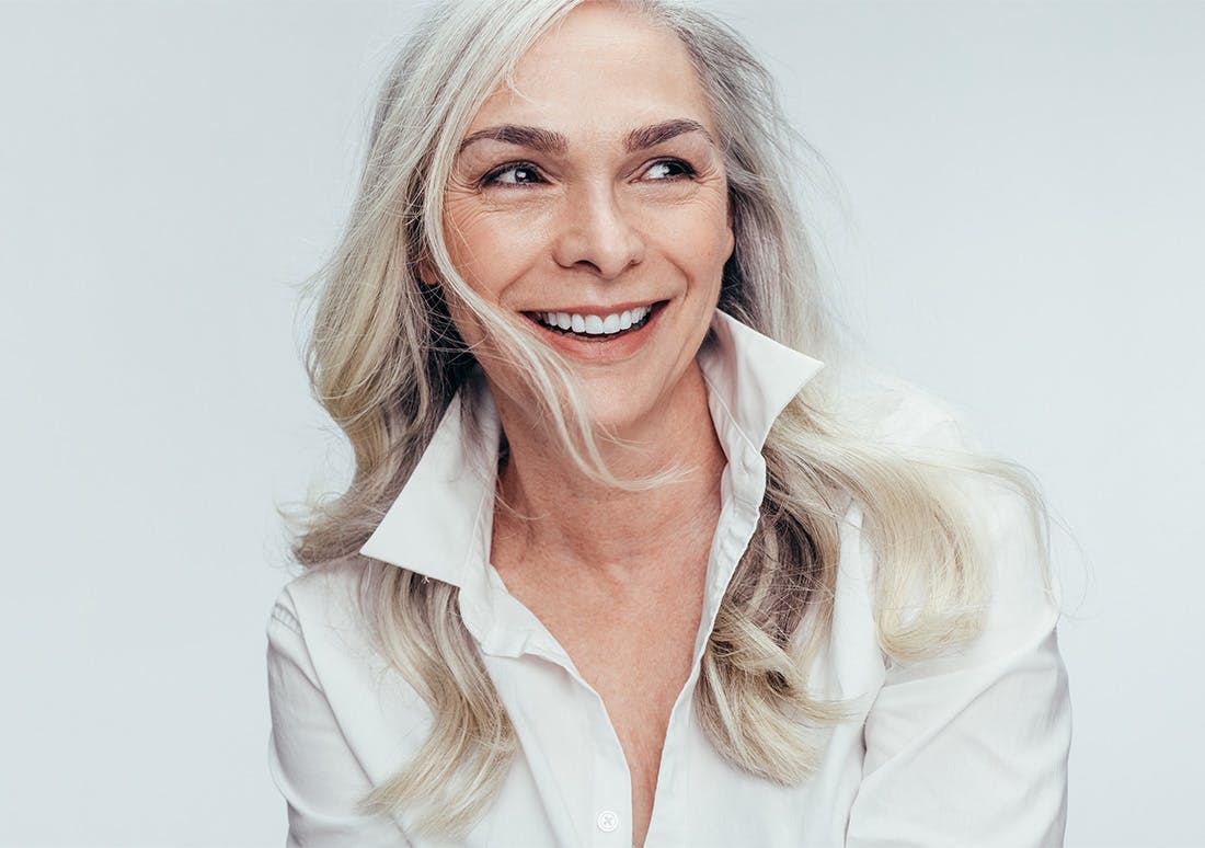 older woman with long white hair smiling