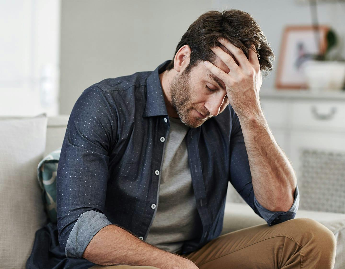man leaning his head on his hand