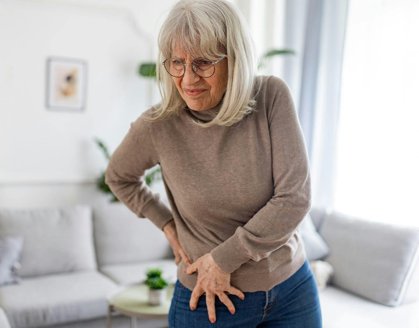 older woman holding her hip in pain