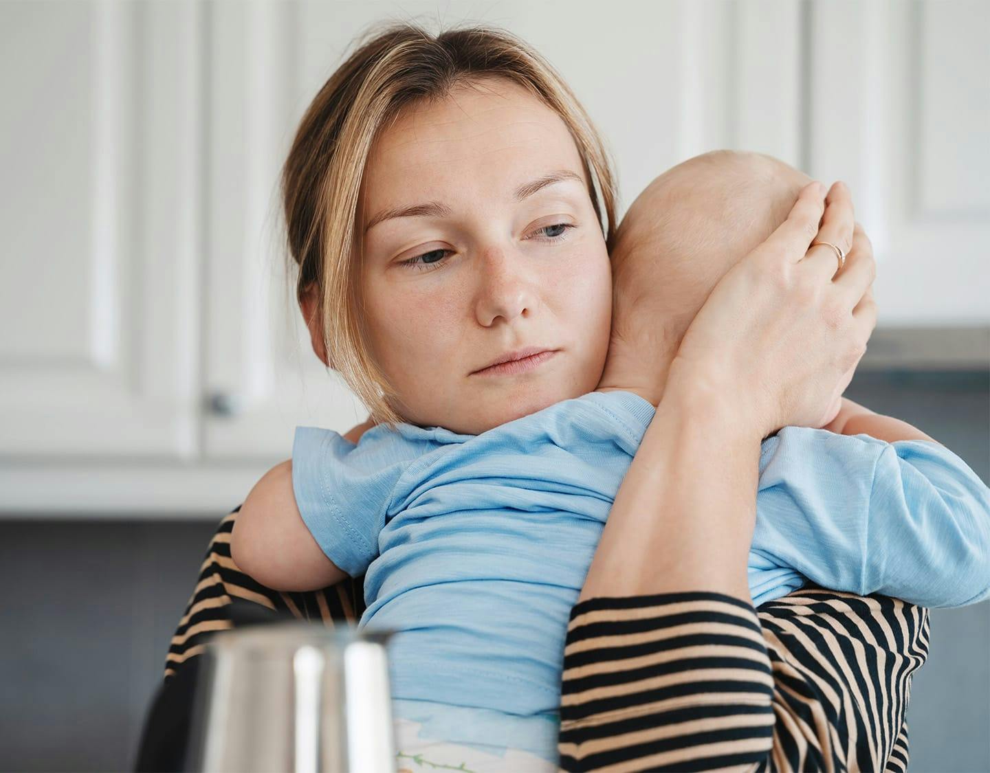 woman holding a baby on her shoulder