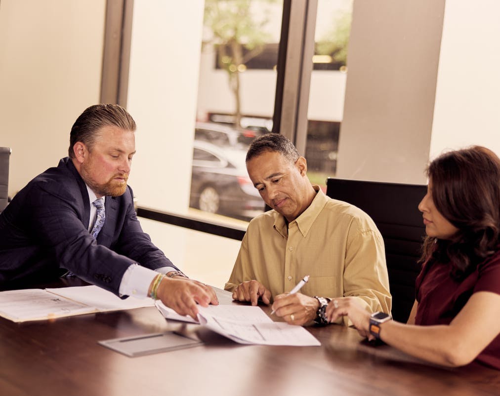 People sitting at a desk signing papers