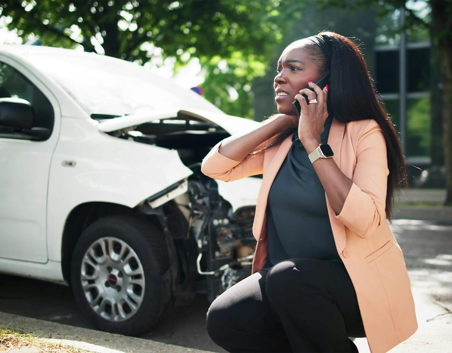 Woman on the phone in front of a car accident