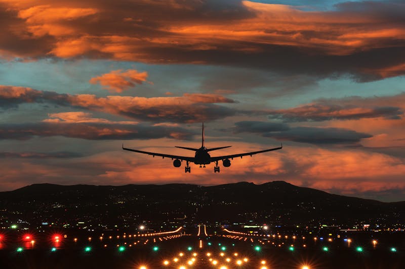 Airplane flying at sunset