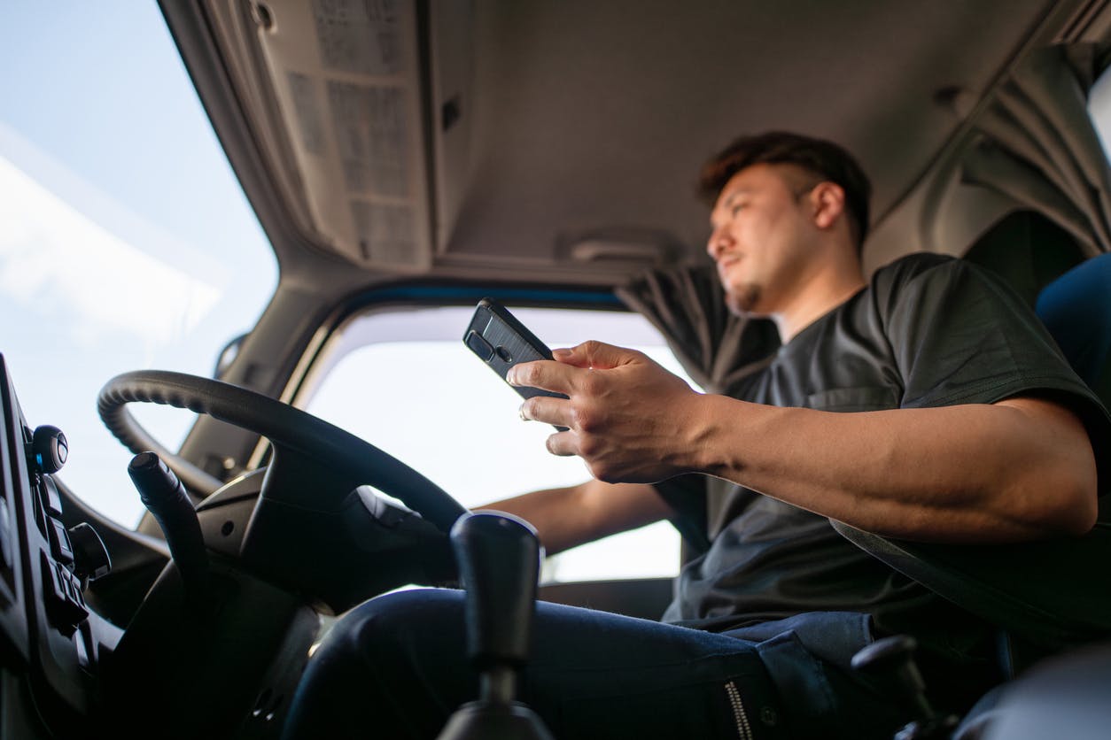 A truck driver holding phone in his hand