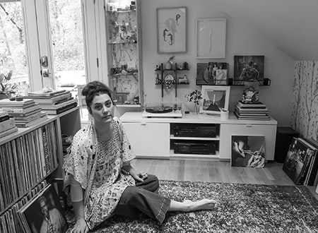 Katy Clove sat in front of their record collection
