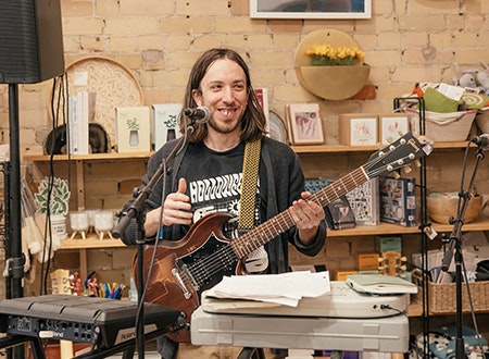 Musician performing with guitar at Tiny Record Shop.