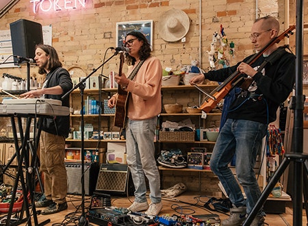 TRS_RSD_Chloe_Lukas_6.jpg A trio band performing with instruments at Tiny Record Shop.