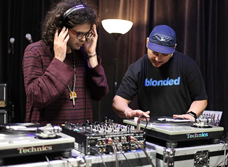 DJ spinning on turntable while listener enjoys music through headphones.