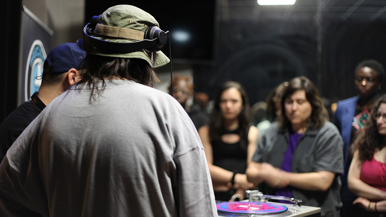 DJ performing while a crowd DJ performing for crowd of spectators: at a live event.