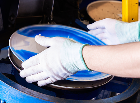 Blue and white vinyl record in manufacturing: Freshly trimmed with vivid swirls of color, ready for packaging