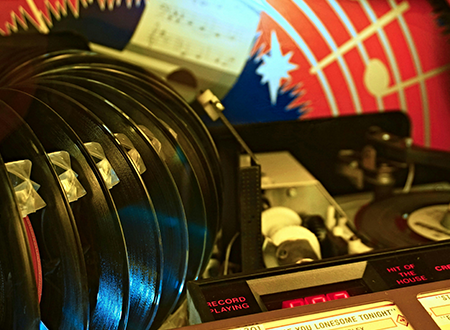 Jukebox filled with assorted 7-inch vinyl records: colorful labels and album covers of various genres.