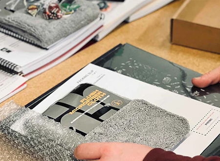 Employee at Sheet Happens Productions packing an order for a customer
