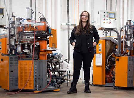 WIV-Machine.png Jenn D'Eugenio standing in front of vinyl presses on a plant floor.