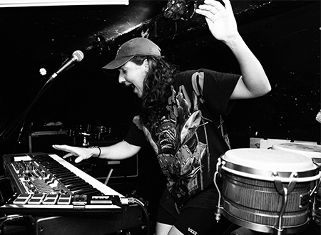Musician singing and playing the keyboard onstage.