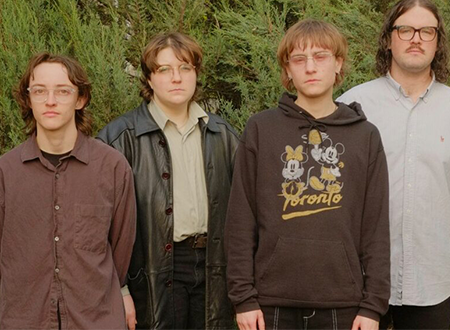Knitting band standing in front of trees.