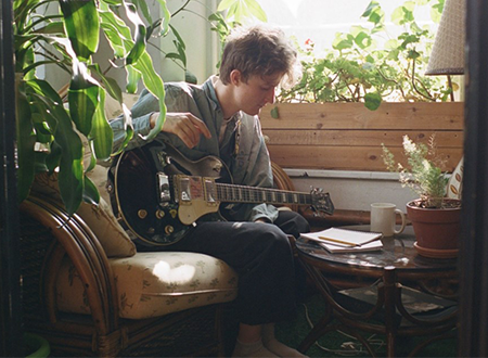 Nicolas Cangiano playing guitar at a cafe.