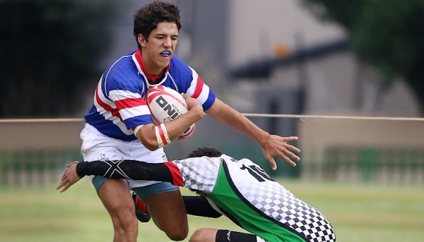 Boy playing footy with mouthguard in