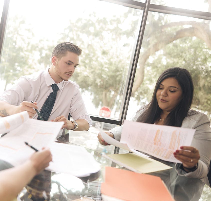 three people at a table looking at documents
