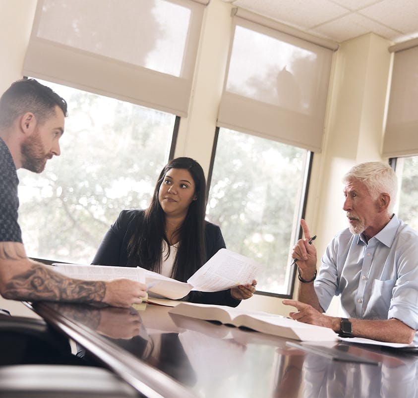 three people talking around a table