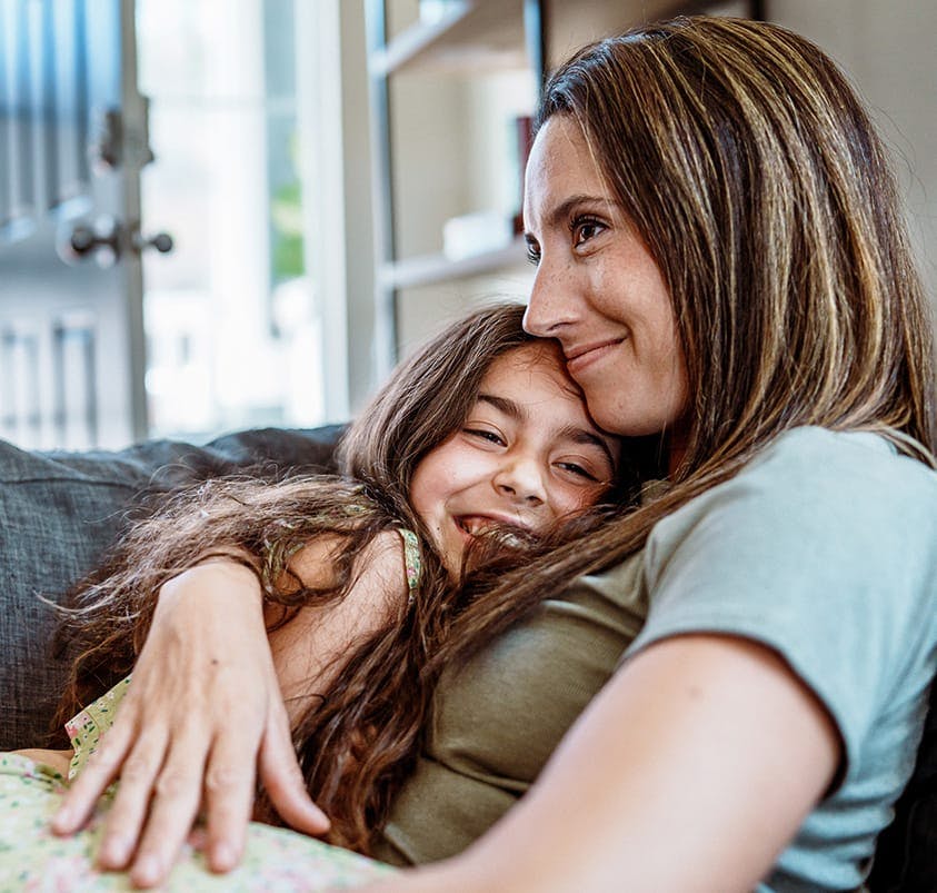 woman hugging a little girl